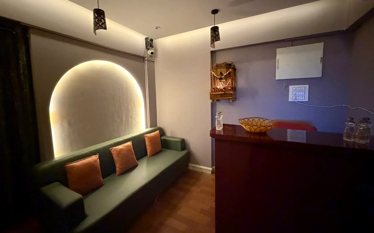 Reception at ILA Spa, a spa in Borivali West — a green sofa beneath a softly lit arch