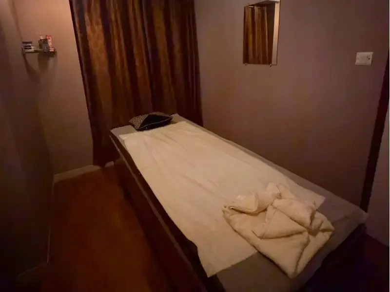 Private massage room at ILA Spa, a spa in Borivali West, with folded towels on the bed